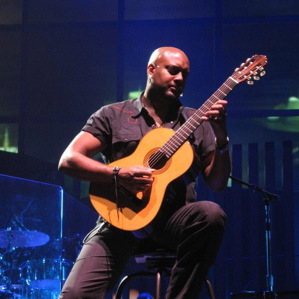 Tariqh Akoni playing acoustic guitar live