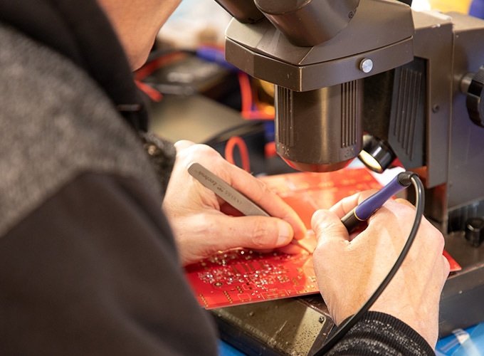 Image of Hutch soldering a circuit board for Radial's HDI direct box.